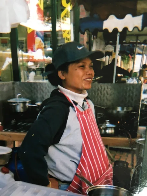 Niang, Tippy's mother, smiling at her original Thai street food market stall