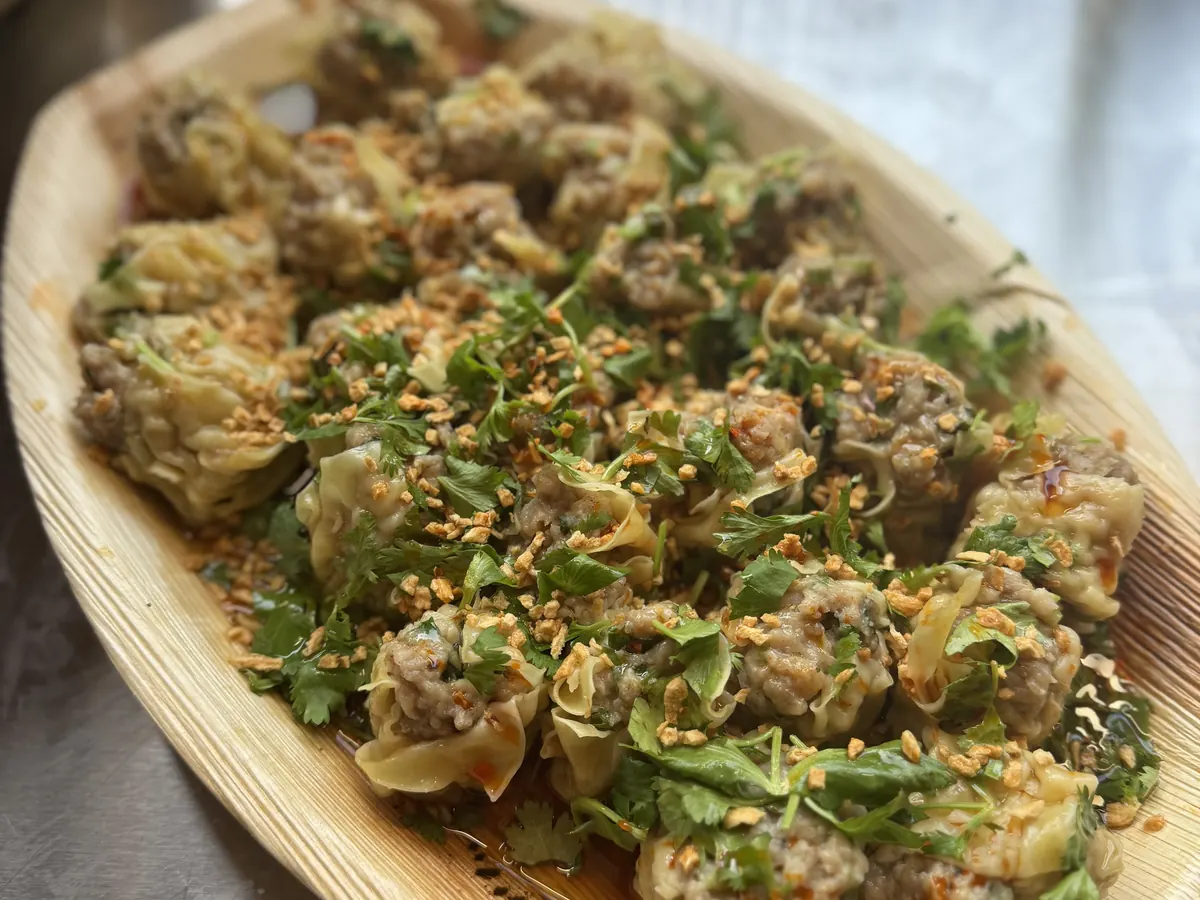 Steamed dumpling canapés garnished with coriander and sesame, served at a Tippy's Thai catered event